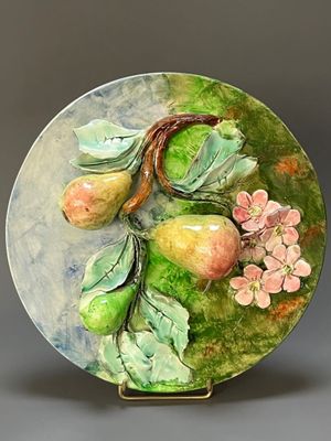 une assiette posée sur une table, sur laquelle sont disposés des fruits et des fleurs