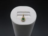 a close up of a ring with a green stone in it