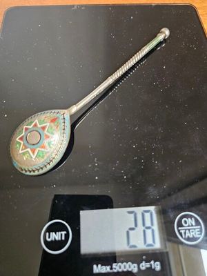 une cuillère posée sur une balance, elle-même posée sur une table