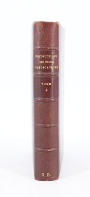 un vieux livre à la couverture brune posé sur une surface blanche