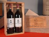 three bottles of wine in a wooden box on a table