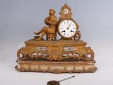 une horloge en or posée sur une table, à côté d'autres objets