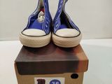une paire de chaussures bleues posée sur une boîte, elle-même posée sur une surface blanche
