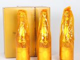 three bottles of gold colored liquid sitting next to a box