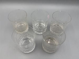 six verres d'eau posés sur une surface blanche