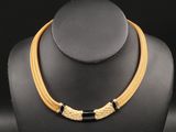 un collier doré et noir autour du cou d'un mannequin