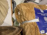 a brown teddy bear sitting on a shelf next to a hat