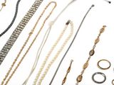 many different types of necklaces and bracelets on the table