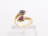 a close up of a yellow gold ring with a blue and red stone