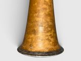 an old brass bell on a white surface with a silver band around it