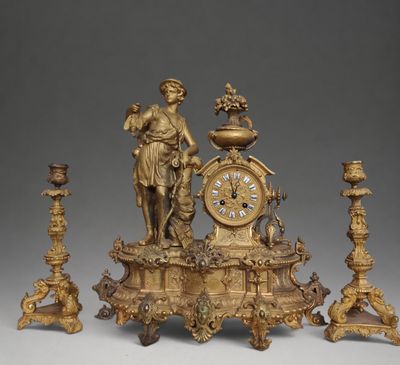 a gold clock with a statue on top of it