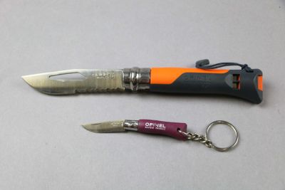 a knife and a keychain sitting on a table