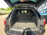 the back of a car with its trunk open on the side of the road