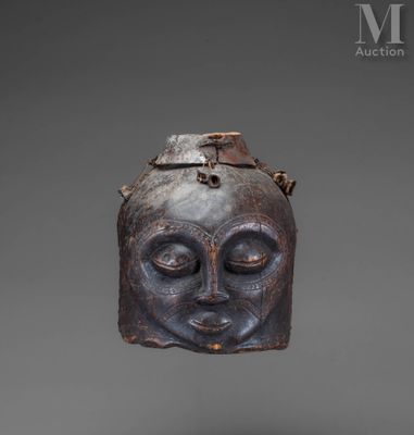 a close up of a wooden mask on a gray background