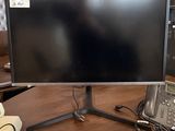a computer monitor sitting on top of a wooden desk