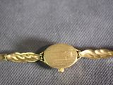 a close up of a gold bracelet with a round clasp