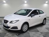une voiture blanche garée sur un sol en damier dans un garage