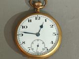 a gold pocket watch hanging on the wall