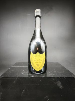 une vieille bouteille de champagne posée sur une boîte noire