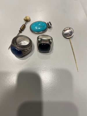deux bagues, une épingle, une broche et une bague posées sur une table
