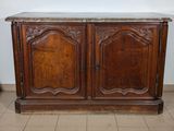 an old wooden cabinet with a marble top on a tiled floor