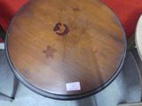 a wooden table with a flower design on the top of it