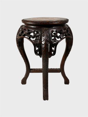 an old wooden table with a carved top and a wooden base