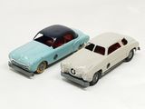 two toy cars sitting next to each other on a white surface
