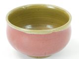 a pink and green bowl sitting on a white surface