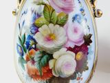 a vase with flowers painted on it sitting on a stand