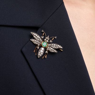 a close up of a person wearing a suit and a broochet