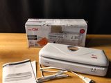 a white stapler sitting on top of a table next to a box