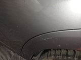 a close up of a car ' s front bumper and tire