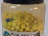 a jar filled with yellow and blue food next to a bottle of water