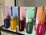 bottles of various colored liquids are on a shelf in a room