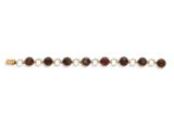 un gros plan d'un bracelet orné de perles sur un fond blanc