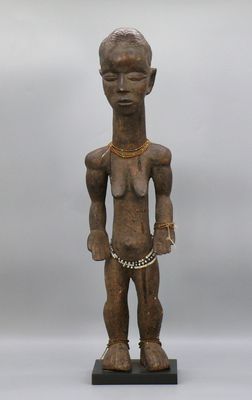 une statue en bois représentant un homme avec une chaîne autour du cou