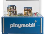 une vitrine Playmobil contenant une maison de poupées
