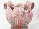 a pink vase sitting on a white surface with a white background