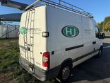 a white van parked in a parking lot with a ladder on the roof