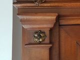 une horloge posée sur le côté d'un meuble en bois