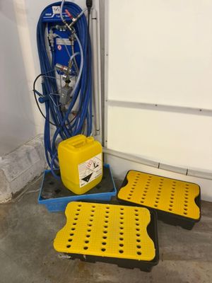 deux boîtes jaunes et noires, avec un tuyau bleu et un récipient jaune