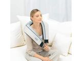 La femme est assise sur le canapé, le cou enveloppé dans une serviette.