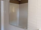 a bathroom with a sink, mirror, and shower in it