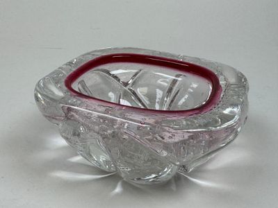 un saladier en verre à bord rouge posé sur une table