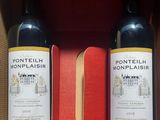 two bottles of wine sitting in a box on a table