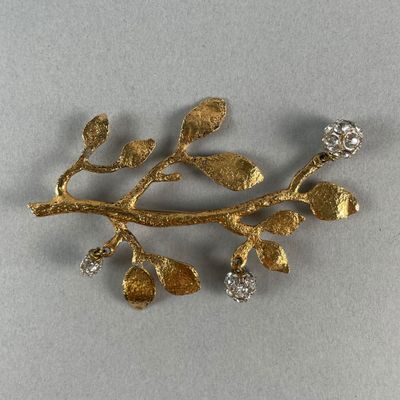 une image représentant une broche en or et diamants ornée de feuilles