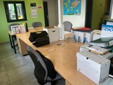 a desk with a computer, printer, and other office supplies on it