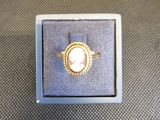 une bague sur laquelle est gravée l'image d'une femme, dans une boîte