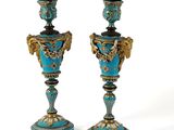 pair of blue and gold vases on pedestals against a white background